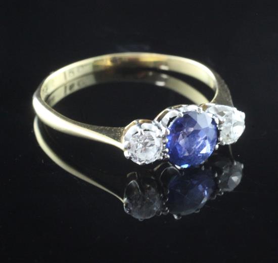 An early 20th century 18ct gold three stone sapphire and diamond ring, size Q.